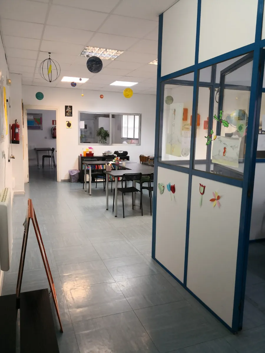 Aula de Academia NOME, con mesas de estudio y planetas colgando del techo