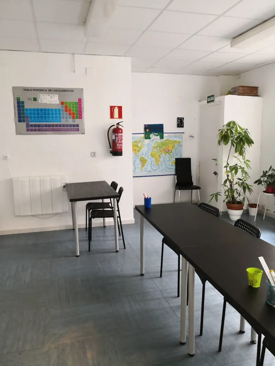 Aula de Academia NOME con tabla periódica, mapa del mundo y mesas de estudio